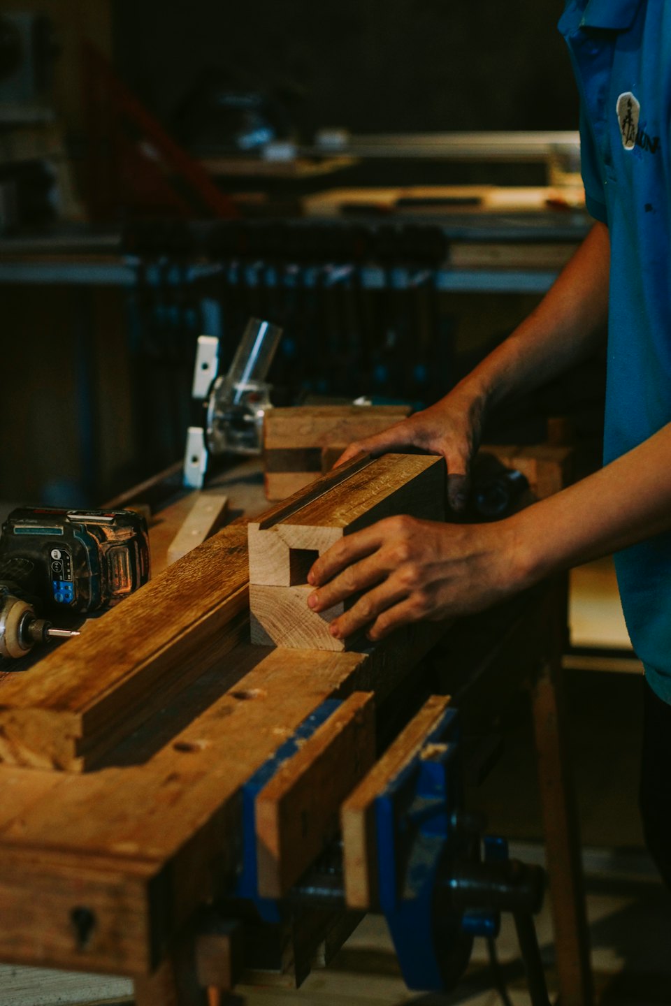 Woodworker fitting a wooden joint together on a workbench.